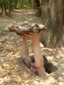 Dave getting into an example of a hiding place at the Cu Chi Tunnels - it's completely camouflaged once he puts that thing over his head!